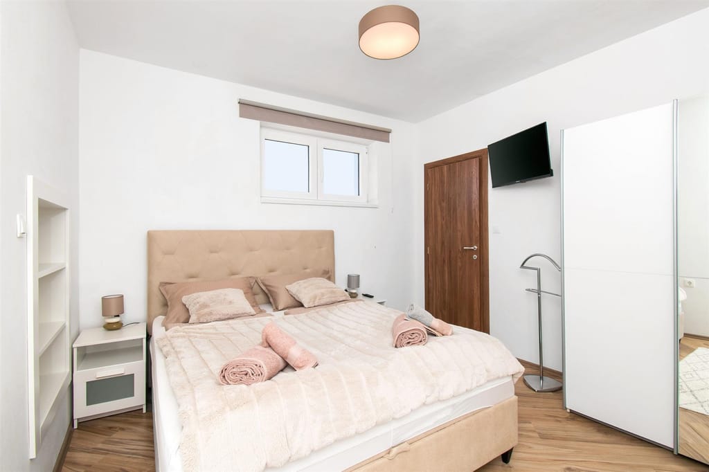 Double bedroom with an upholstered headboard and fresh towels