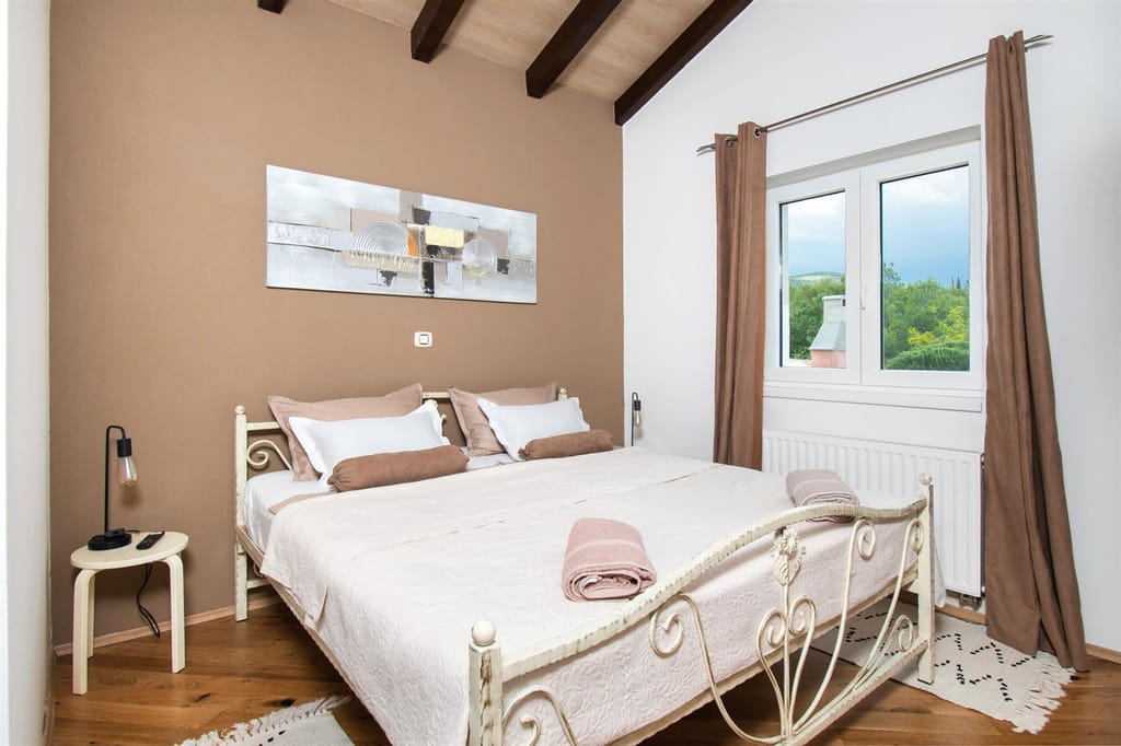 Bedroom with a wrought-iron double bed and a beamed ceiling