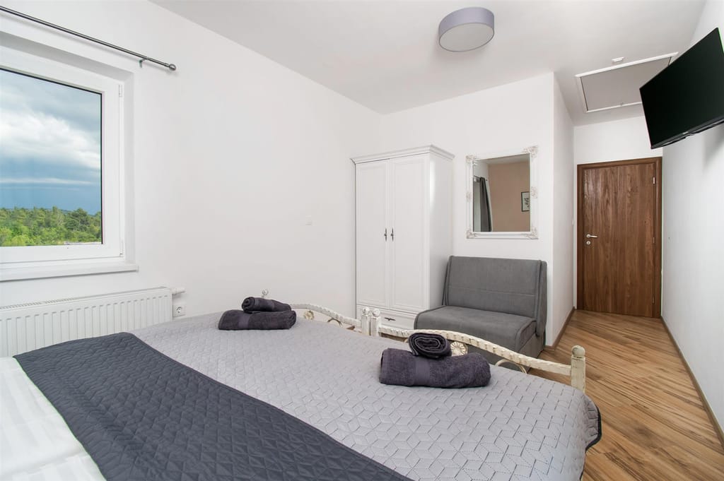 Twin bedroom with a sofa bed and a wall-mounted TV