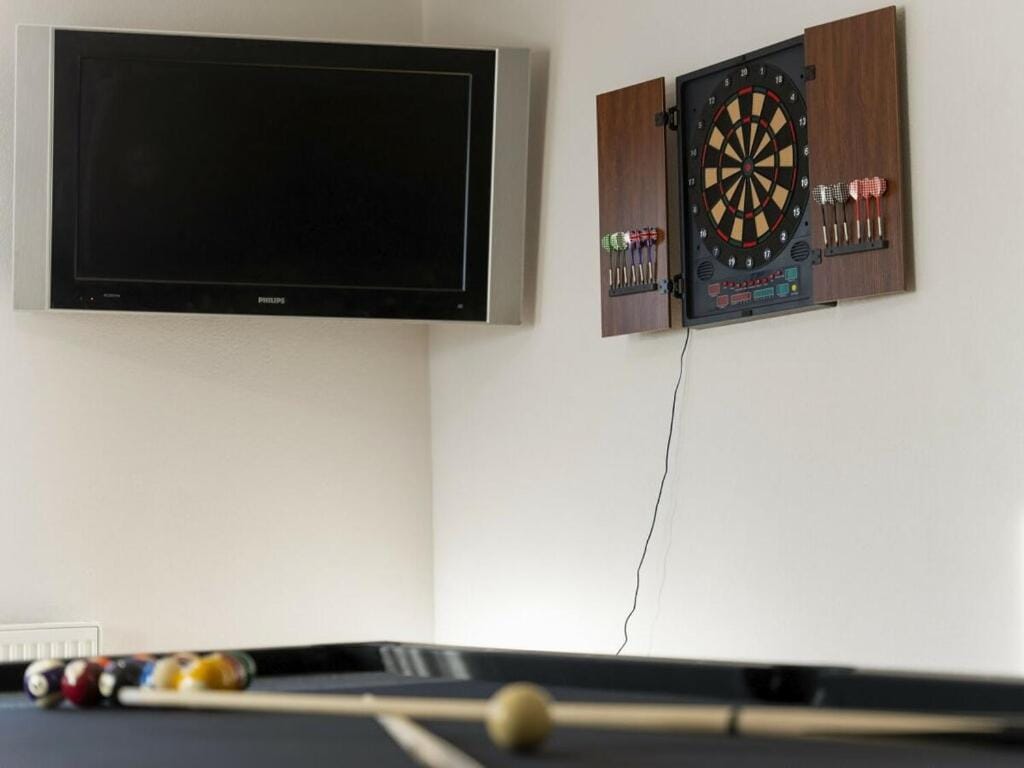 Dartboard and TV above the billiard table
