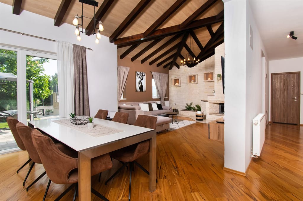 Open living and dining area with a corner sofa and a beamed ceiling